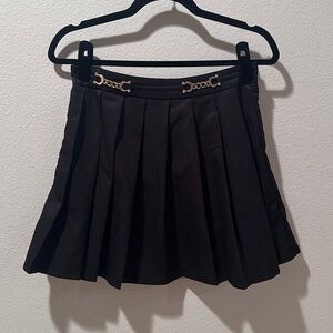 Black pleated skirt with gold chain accents